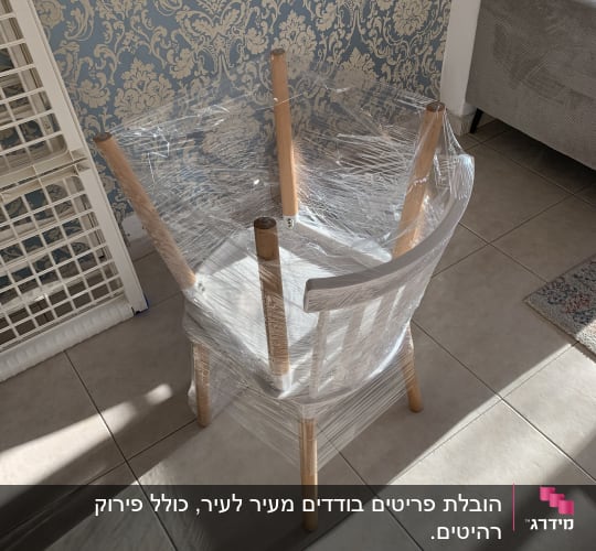 כיסא עטוף בניילון נצמד למעבר דירה